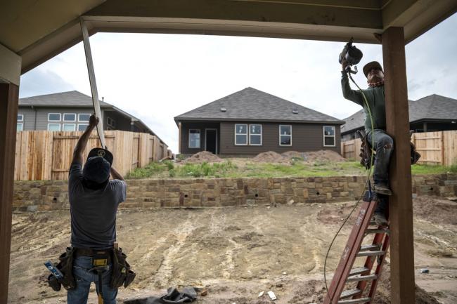 © Bloomberg. Workers add boards to the exterior of a home at a construction site in a new residential development near Buda, TX on Wednesday, May 15, 2021. Companies that build these homes like Castle Rock are cutting back on orders because the demand and rising price in commodities. Sergio Flores/Bloomberg