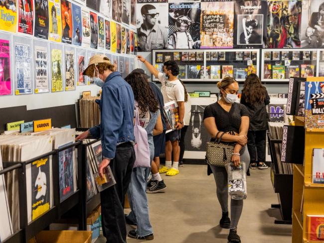 © Bloomberg. Shoppers wearing protective masks browse at an Amoeba Music store in Los Angeles. Photographer: Roger Kisby/Bloomberg