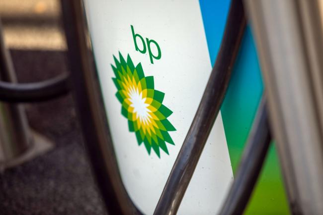 © Bloomberg. The BP Plc company logo on an electric vehicle charging point in Milton Keynes, U.K., on Tuesday, Feb. 9, 2021. BP aims to cut its oil and gas production by 40%, increase low-carbon spending to $5 billion a year and produce 50 gigawatts of renewable energy by the end of the decade. Photographer: Chris Ratcliffe/Bloomberg