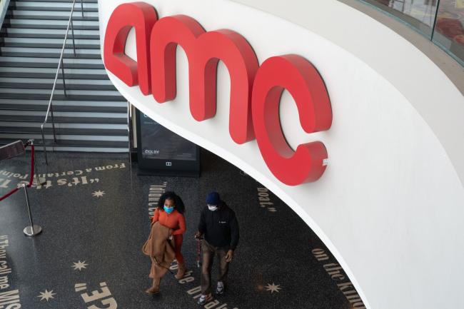 © Bloomberg. Moviegoers walk through the AMC movie theater. Photographer: Bing Guan/Bloomberg