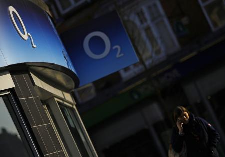 © Reuters/Darren Staples. A woman speaks on her mobile telephone outside an O2 shop in Loughborough, central England, Jan. 23, 2015.