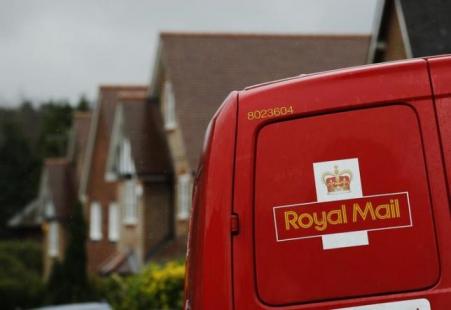 © Reuters/Luke MacGregor. A Royal Mail postal van is parked outside homes in Maybury near Woking in southern England on March 25, 2014.