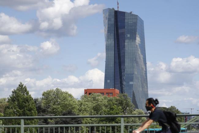 © Bloomberg. A cyclist wearing a protective face mask passes the European Central Bank (ECB) headquarters in Frankfurt, Germany, on Wednesday, April 29, 2020. The ECB’s response to the coronavirus has calmed markets while setting it on a path that could test its commitment to the mission to keep prices stable.