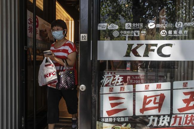 © Bloomberg. A customer exits a KFC restaurant operated by Yum China Holdings Inc. in Beijing, China. Photographer: Gilles Sabrie/Bloomberg