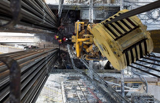 © Bloomberg. FILE PHOTO: Oil workers operate drill sections while working on the drilling floor beneath the travelling block, right, on a derrick operated by Salym Petroleum in Salym, Khanty-Mansi autonomous region, Russia, on Tuesday, July 2, 2013. Oil extended losses below $60 a barrel amid speculation that OPEC's biggest members will defend market share against U.S. shale producers. Photographer: Bloomberg/Bloomberg