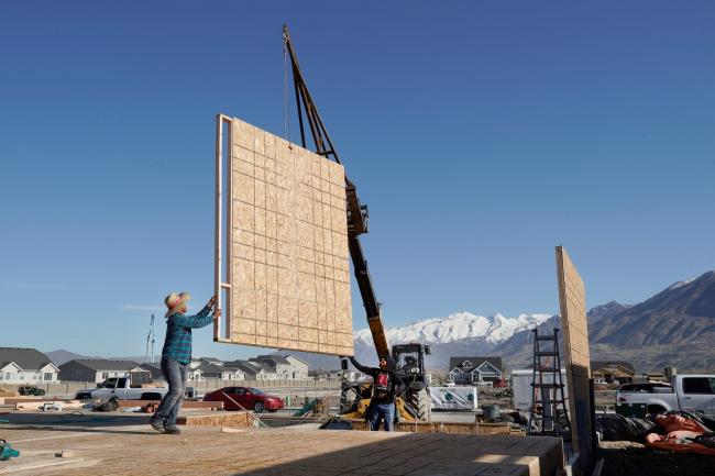 © Bloomberg. Contractors direct a section of a wall frame into place during the construction of a home in Lindon, Utah. Photographer: George Frey/Bloomberg