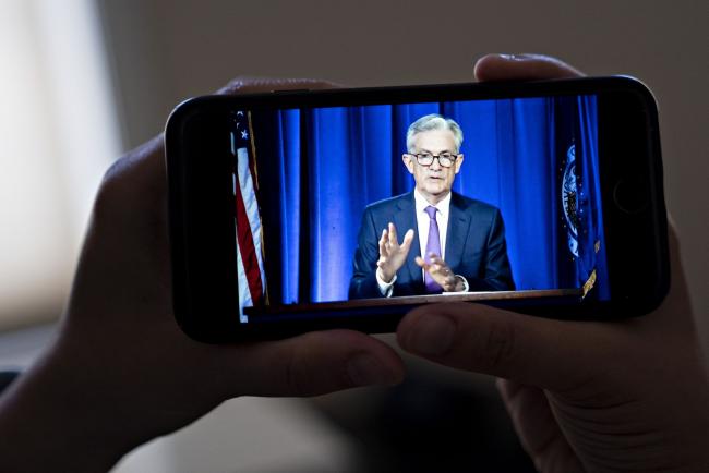 © Bloomberg. Jerome Powell, chairman of the U.S. Federal Reserve, speaks during a virtual news conference seen on a smartphone in Arlington, Virginia, U.S., on Wednesday, July 29, 2020. Federal Reserve officials left their benchmark interest rate unchanged near zero and again vowed to use all their tools to support the U.S. economy amid a shaky recovery from the coronavirus pandemic.