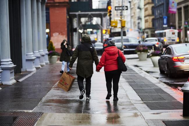 © Bloomberg. Pedestrians holding hands walk with a Bloomingdale's Inc. shopping bag while in the SoHo neighborhood of New York, U.S., on Monday, Dec. 14, 2020. The U.S. Census Bureau is scheduled to release retail sales figures on December 16. Photographer: Gabby Jones/Bloomberg