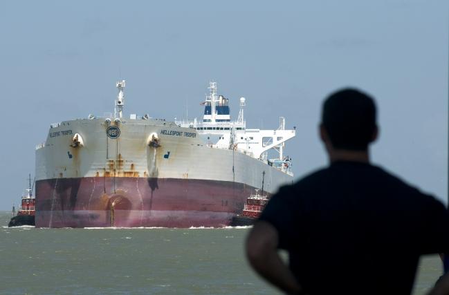 © Bloomberg. UNITED STATES - JUNE 12: A man watches the double hulled oil tanker Hellespont Trooper enter the Port of Corpus Christi, Texas, U.S., on Thursday, June 12, 2008. Crude oil fell as Saudi Arabian Oil Minister Ali al-Naimi said record prices are ``unjustified'' and the state oil company signaled it may soon start pumping from a new field. (Photo by Eddie Seal/Bloomberg via Getty Images) Photographer: Bloomberg/Bloomberg