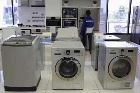 © Reuters/Siphiwe Sibeko. Samsung washing machines are seen as an employee inspects refrigerators at a Samsung display store in Johannesburg, on Oct. 3, 2013.