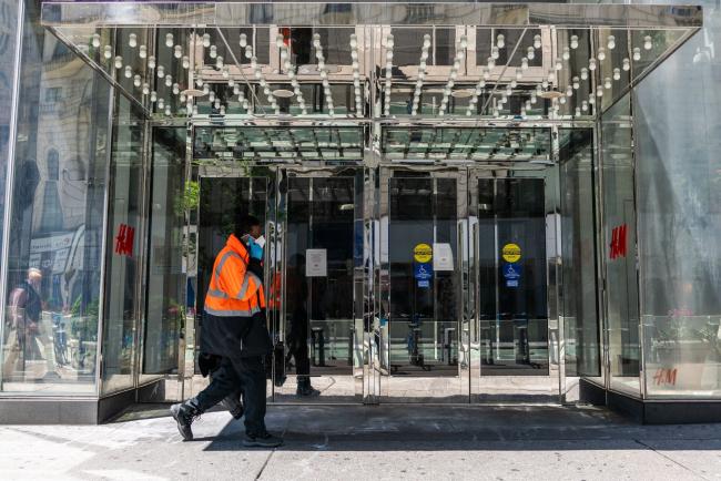 © Bloomberg. A pedestrian wearing a protective mask passes in front of a Hennes & Mauritz (H&M) store temporarily closed in the Herald Square area of New York, U.S., on Tuesday, May 12, 2020. New York City's lockdown is likely to continue into June, Mayor Bill de Blasio said Monday at a press briefing. The state has been under lockdown since March in an attempt to stop the spread of the novel coronavirus. Photographer: Demetrius Freeman/Bloomberg