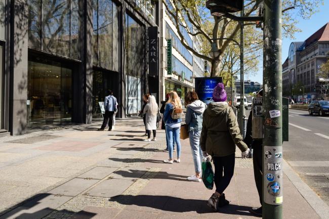 © Bloomberg. Customers form a social distancing queue to enter a Zara fashion store, operated by Inditex SA, as it reopens for business in Berlin, Germany, on Wednesday, April 22, 2020. The number of new coronavirus cases in Germany stayed close to a three-week low as the country begins gradually lifting pandemic-related lockdown measures. Photographer: Jacobia Dahm/Bloomberg