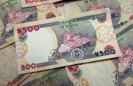 © Dan Kitwood/Getty Images. The Nigerian naira devalued by N5 to N220 per U.S. dollar as Nigerians seek the United States currency to pay for school abroad and the annual Hajj pilgrimage to Mecca. Pictured: A detail of some Nigerian naira being counted in an exchange office, July 15, 2008, in Lagos, Nigeria.