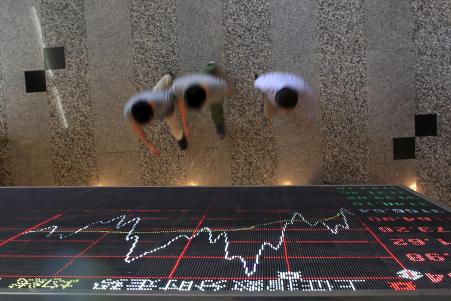 © Reuters/Aly Song. People walk under an electronic board showing stock information at the Shanghai Stock Exchange in Lujiazui Financial Area, Sept. 22, 2015.