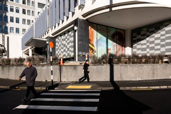 © Bloomberg. Pedestrians walk past the Reserve Bank of New Zealand (RBNZ) headquarters in Wellington, New Zealand, on Thursday, Aug. 9, 2018. New Zealand's central bank said it expects to keep interest rates at a record low for another two years as the outlook for economic growth weakens.