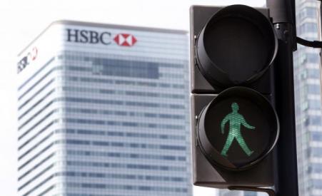 © Reuters/Cathal McNaughton. The HSBC building is seen in the background as the green man flashes at a pedestrian crossing in East London on April 17, 2015.