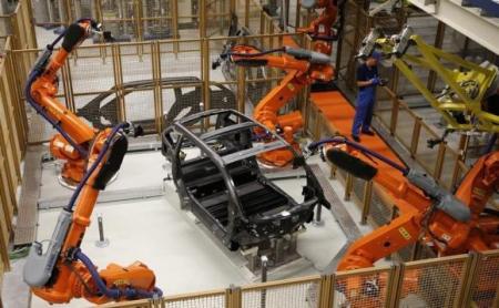 © Reuters/Fabrizio Bensch. A worker makes technical measurements with robots on the carbon chassis at the serial production BMW i3 electric car in the BMW factory in Leipzig on Sept. 18, 2013.