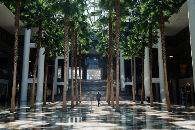© Bloomberg. A man walks across the empty atrium of a shopping mall in Manhattan on May 5.