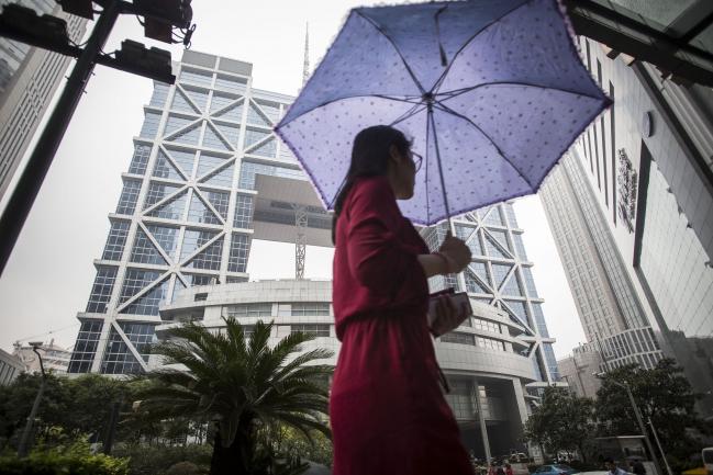 © Bloomberg. A pedestrian carrying an umbrella walks past the Shanghai Stock Exchange building in Shanghai, China, on Tuesday, Sept. 22, 2015.  Photographer: Qilai Shen/Bloomberg 