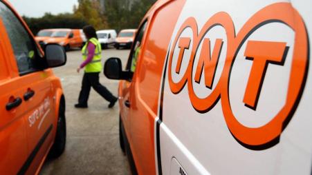 © Reuters/Darren Staples. A worker walks past TNT delivery vans at a sorting office in Wellingborough, England.<br/>