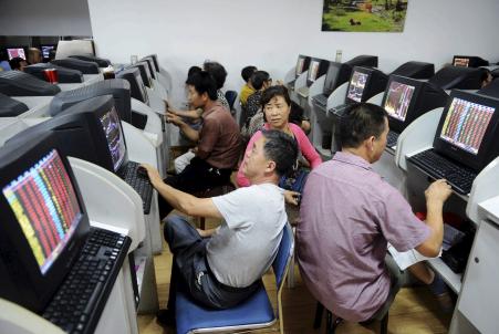 © Reuters. Poor economic news has raised hopes of further economic stimulus in China, bolstering the country's stock market. In this photo, investors chat in front of computer screens showing stock information at a brokerage house in Qingdao, Shandong province, China on Aug 10, 2015.