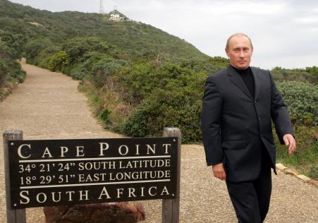 © Reuters/Howard Burditt. Russian President Vladimir Putin walks away from a signpost after posing for photographs at Cape Point, south of Cape Town, September 6, 2006.