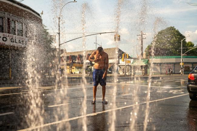 © Bloomberg. A person is sprayed with water from a fire hydrant in the Bronx borough of New York, U.S., on Saturday, July 20, 2019. Consolidated Edison Inc. is forecasting record power demand for New York this weekend as a heat wave blankets the city. Photographer: David Dee Delgado/Bloomberg