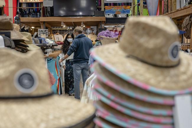 © Bloomberg. Shoppers wearing protective masks browse clothing at a store in Long Beach, New York, U.S., on Thursday, June 11 2020. Long Island officially entered Phase 2 of its reopening from the coronavirus pandemic Wednesday, with outdoor dining and some in-store retail stores are back in business for the first time in weeks. Photographer: Johnny Milano/Bloomberg