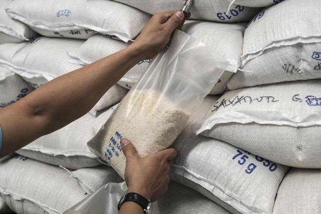 © Bloomberg. A worker inspects the quality of a sack of rice inside a National Food Authority warehouse in Valenzuela, Metro Manila, the Philippines, on Thursday, March 26, 2020. The Philippines plans to buy rice from Thailand and Vietnam under a government-to-government deal to help boost supply during the lean months. The plan comes as Vietnam ordered a halt to rice exports to ensure food security during the novel coronavirus outbreak. Photographer: Veejay Villafranca/Bloomberg