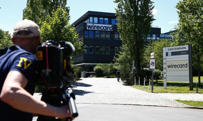 © Bloomberg. A television news camera operator films outside the Wirecard headquarters during a police and prosecutors raid in Munich, Germany.