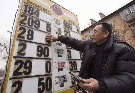 © Reuters/Shamil Zhumatov. Kazakhstan's tenge plunged on Thursday as the country moved to a free-floating currency. In this photo, an employee changes an exchange rate at a currency exchange office in Almaty on Feb 24, 2015.