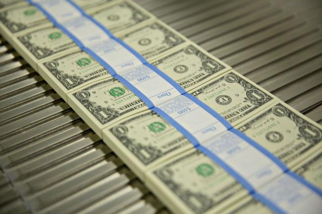 © Bloomberg. Stacks of $1 dollar notes bearing the name of U.S. Treasury Secretary Steven Mnuchin move through a machine at the U.S. Bureau of Engraving and Printing in Washington, D.C., U.S., on Wednesday, Nov. 15, 2017. A change in the Senate tax-overhaul plan that would expand a temporary income-tax break for partnerships, limited liability companies and other so-called 