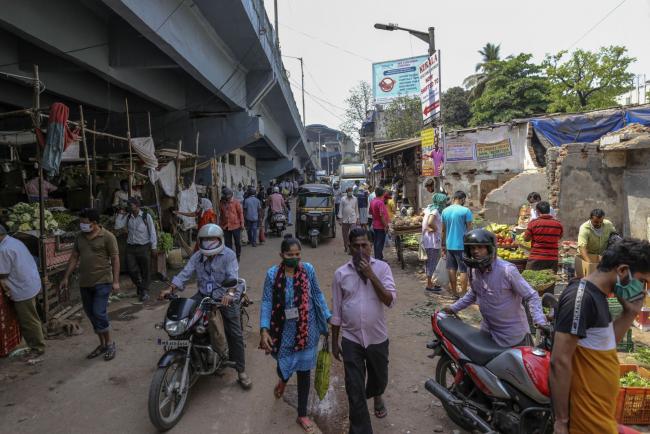 © Bloomberg. Pedestrians and shoppers wear protective masks and other face coverings at a vegetable market in Mumbai, India, on Wednesday, March 25, 2020. India imposed a three-week long nationwide lockdown for its 1.3 billion people, the most far-reaching measure undertaken by any government to curb the spread of the coronavirus pandemic. Photographer: Dhiraj Singh/Bloomberg