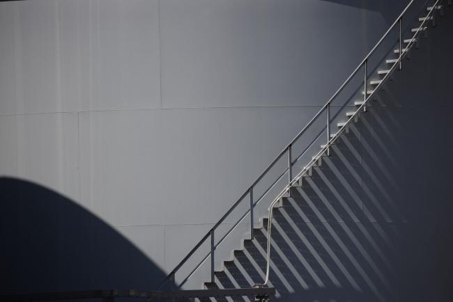 © Bloomberg. A staircase ascends a storage tank located near a dock for Hornbeck Offshore Services, Inc. oil industry support vessels in Port Fourchon, Louisiana, U.S., on Thursday, June 11, 2020. Oil eclipsed $40 a barrel in New York on Friday, extending a slow but relentless rise that’s been fueled by a pick-up in demand and could signal a reawakening for U.S. shale production. Photographer: Luke Sharrett/Bloomberg
