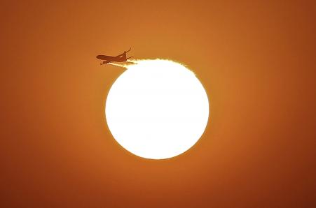 © Reuters/Adnan Abidi. An aircraft files near the setting sun in New Delhi, Nov. 30, 2013.