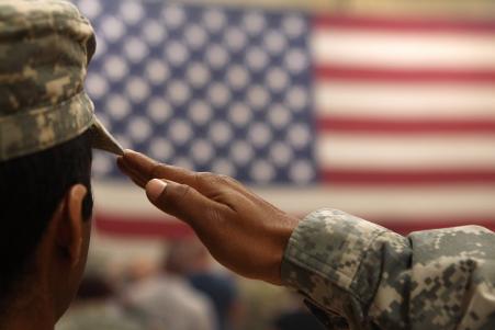© John Moore/Getty Images. A soldier salutes the flag during a welcome home ceremony for troops arriving from Afghanistan on June 15, 2011 to Fort Carson, Colorado.