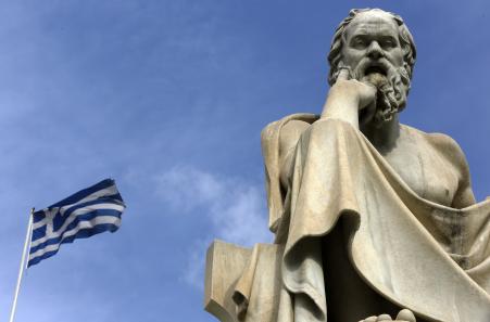 © Reuters/Yannis Behrakis. A Greek flag flutters by a statue of ancient Greek philosopher Socrates in central Athens, March 18, 2015.