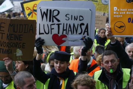 © Reuters/Ralph Orlowski. Lufthansa reached an agreement with labor union Verdi. Pictured: A Lufthansa employee holds up a placard reading 'we are Lufthansa' during a strike by cabin crew union (UFO) at Frankfurt airport, Germany on Nov. 13, 2015.