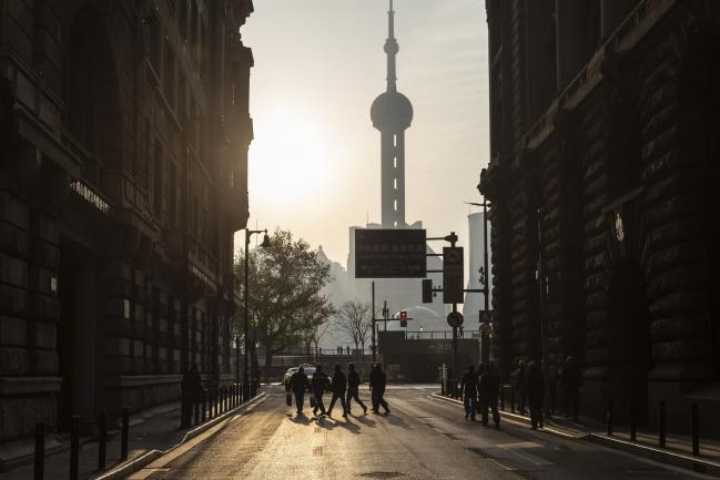 © Bloomberg. Construction workers cross a road near the Bund in Shanghai, China, on Saturday, April 10, 2021. China's population is aging more quickly than most of the worlds developed economies due to decades of family planning aimed at halting population growth. Photographer: Qilai Shen/Bloomberg
