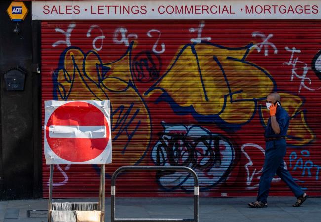 © Bloomberg. A pedestrian passes an estate agent in London, on April 21. Photographer: Chris J. Ratcliffe/Bloomberg