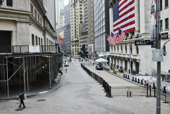 © Bloomberg. Pedestrians walk past the New York Stock Exchange (NYSE) on a nearly empty Wall Street in the Financial District of New York, U.S., on Monday, March 30, 2020. Roughly 37,500 people have tested positive for the coronavirus in New York City, officials said on Monday, up about 3,700 from a day earlier. Photographer: Gabby Jones/Bloomberg