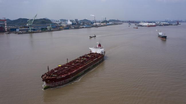 © Bloomberg. The tanker Oceanus Sword sails past a cluster of petrochemical facilities on the shores of the East China Sea in this aerial photograph taken on the outskirts of Ningbo, Zhejiang Province, China, on Wednesday, April 22, 2020. China's top leaders softened their tone on the importance of reaching specific growth targets this year during the latest Politburo meeting on April 17, saying the nation is facing 