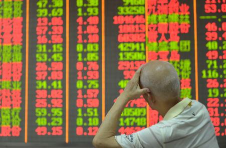 © Getty Images/AFP/STR. An investor checks share prices in a security firm in Shanghai on August 13, 2015.