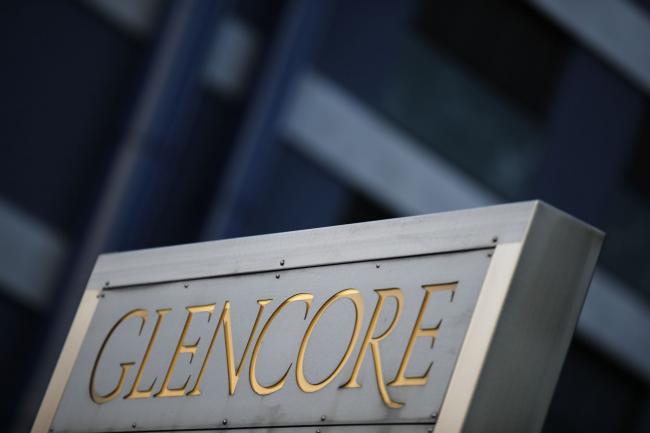 © Bloomberg. Signage stands near the Glencore Plc headquarters office in Baar, Switzerland, on Friday, July 6, 2018. Glencore will buy back as much as $1 billion of its shares, a move that may soothe investor concerns after the worlds top commodity trader was hit by a U.S. Department of Justice probe earlier this week.