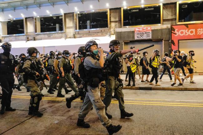 © Bloomberg. Police officers attempt to disperse crowds during a protest on June 12.