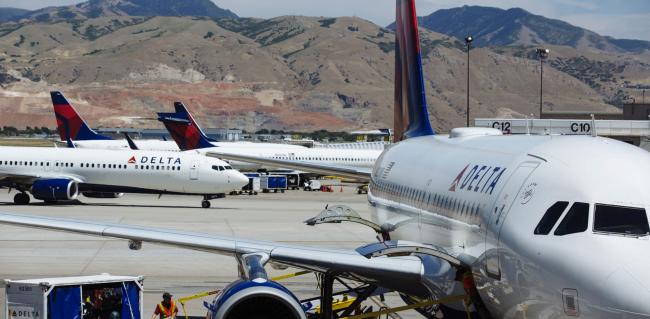 © Bloomberg. A ground crew member loads baggage on a Delta Air Lines Inc. plane at Salt Lake City International airport (SLC) in Salt Lake City, Utah.