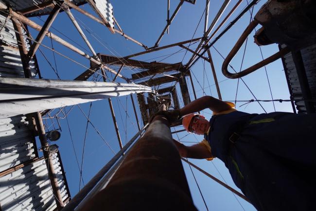 © Bloomberg. A worker positions pipework on the oil drilling platform at the oil and gas field processing and drilling site operated by Ukrnafta PJSC in Boryslav, Lviv region, Ukraine, on Thursday, July 4, 2019. Ukrnafta co-owner, Naftogaz JSC, the largest gas supplier in the country of 42 million people, is seeking funds to accelerate gas purchases ahead of the heating season and a potential disruption of gas transit by Russias Gazprom PJSC from the start of 2020. Photographer: Bloomberg/Bloomberg