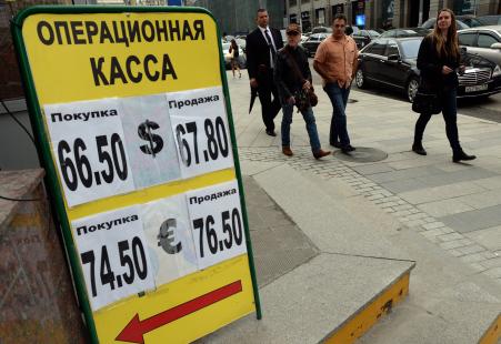 © AFP/Getty Images. Pedestrians walked past a board listing foreign currency rates against the Russian ruble outside an exchange office in Moscow in September.