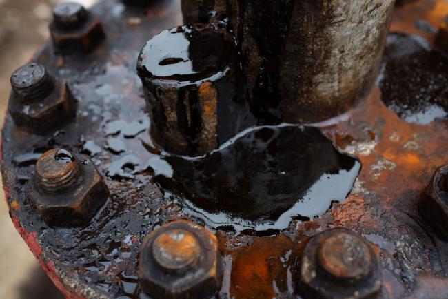 © Bloomberg. Thick black oil sits on the pipe work fitting of an oil pumping jack, also known as 