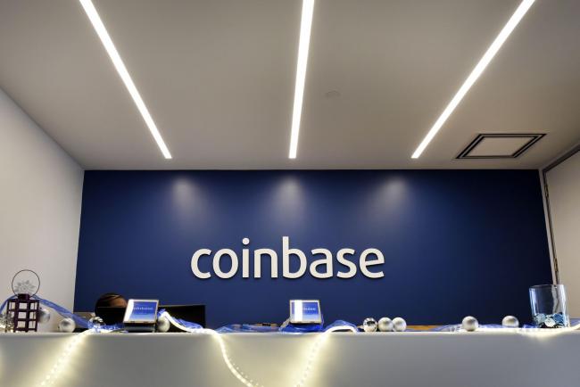 © Bloomberg. Signage is displayed at the front desk of the Coinbase Inc. office in San Francisco, California, U.S., on Friday, Dec. 1, 2017. Coinbase wants to use digital money to reinvent finance. In the company's version of the future, loans, venture capital, money transfers, accounts receivable and stock trading can all be done with electronic currency, using Coinbase instead of banks.